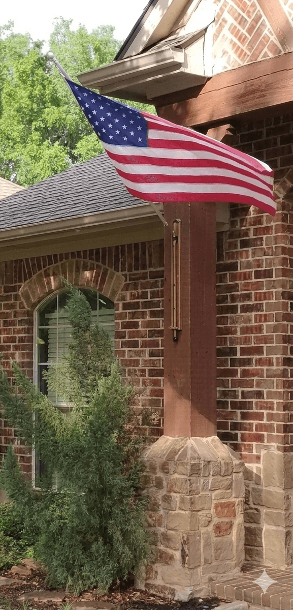 American flag waving in the wind on VersaMAST system mounted on brick home